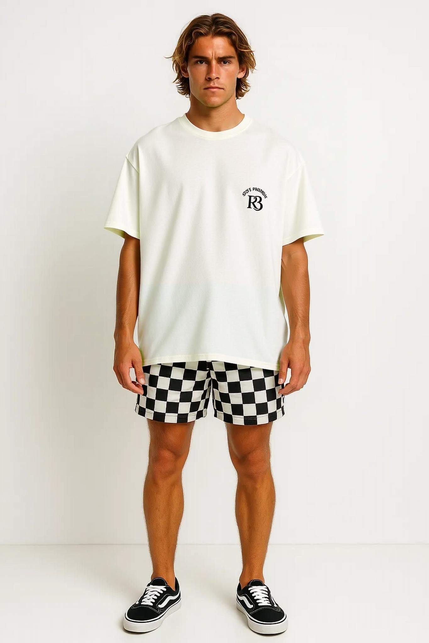Man wearing oversized white God’s Promise 33 tee with R3 logo chest print paired with black and white checkered shorts